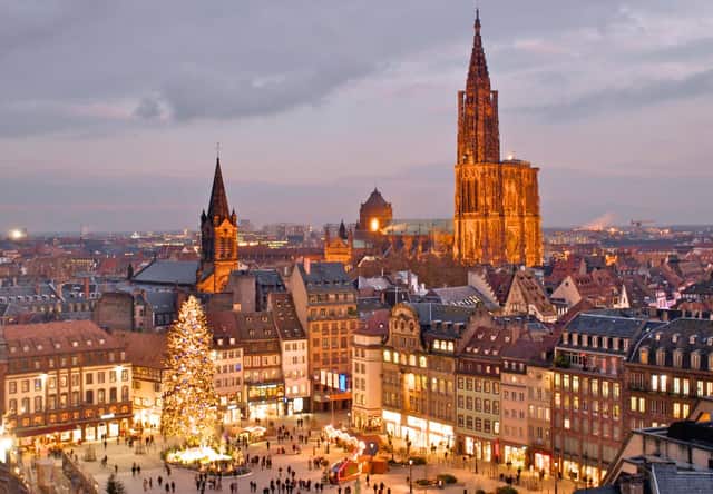 Straßburg in der Abenddämmerung: das erleuchtete Münster und der große Weihnachtsbaum am Place Kléber.