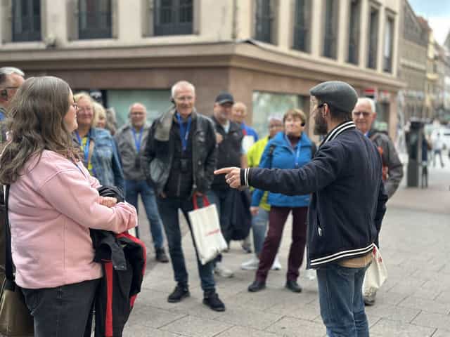 VéloRouge-Guide zeigt einer Gruppe mit Tour-Headsets Straßburg