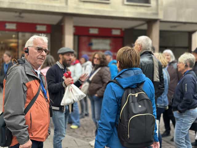Gäste einer Stadtführung in einer Fußgängerstraße in Straßburg